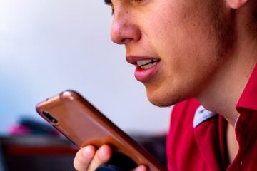 Man with phone in hand looking frustrated listening to a long WhatsApp Voice Note.